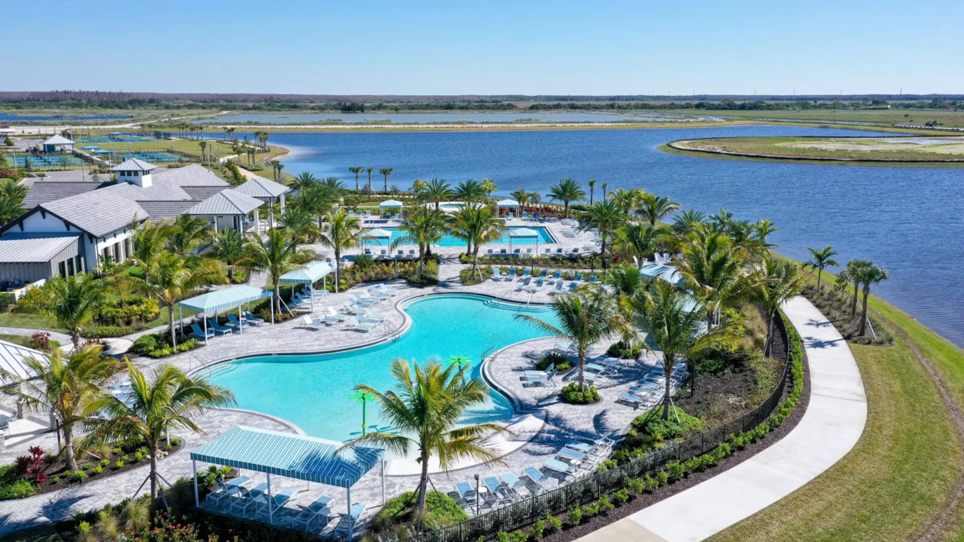 Resort-style pool with palm trees and lake views at a Florida community